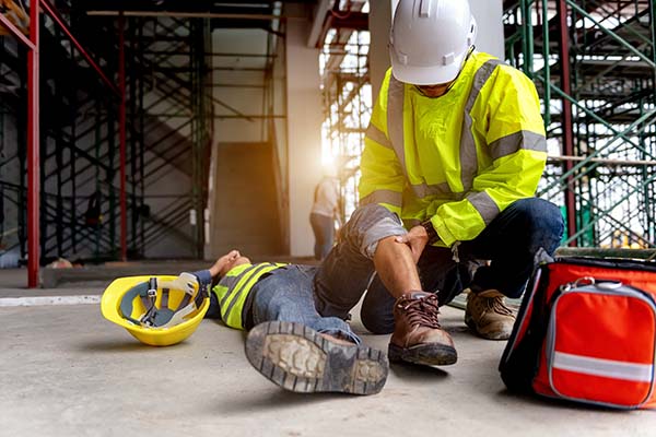 AdobeStock_319617074.jpeg (First aid support accident at work of construction worker at site. Builder accident falls scaffolding on floor, Safety team helps employee accident.)